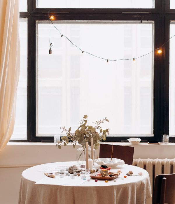 Woman in a calm seated yoga pose in a minimalist, bright room.